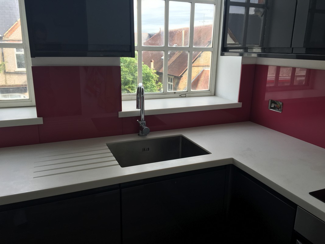 Deep plum coloured glass splashback in modern Shoreditch kitchen